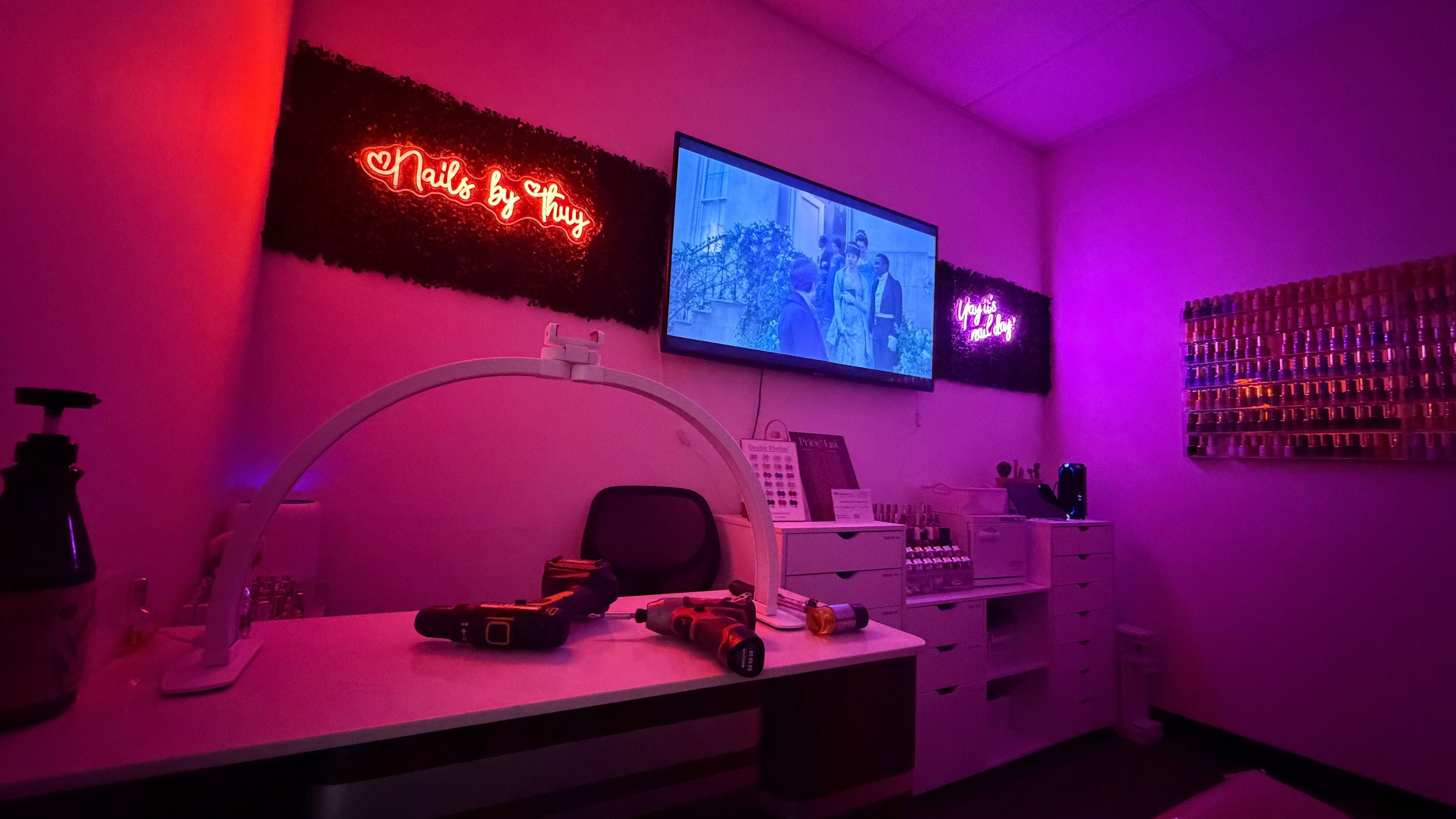 Vibrant nail salon interior at Nails by Thuy, Apple Valley, Minnesota, US with neon lighting and polish display.