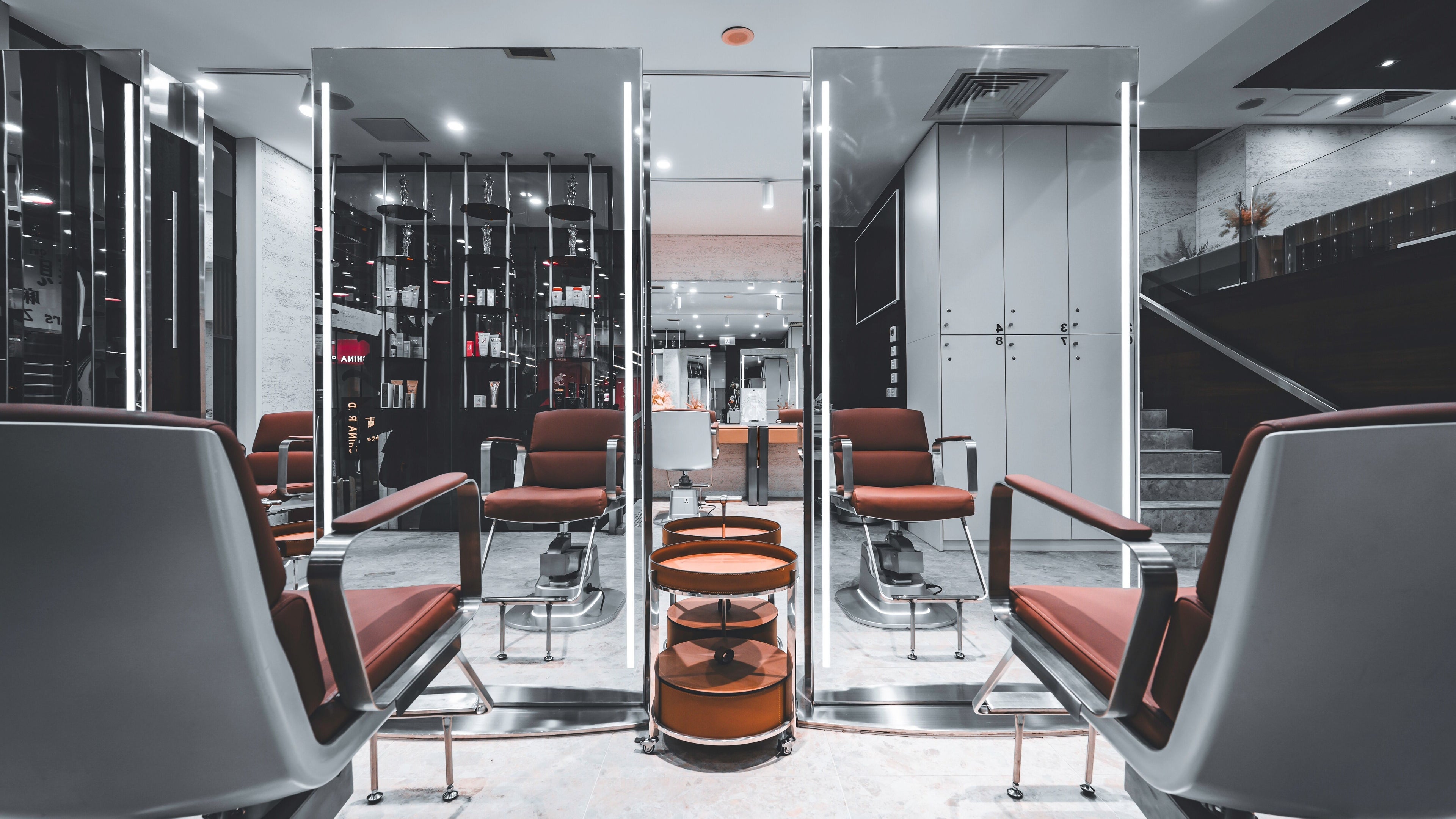 Sophisticated interior of LUXM China Town in Melbourne, Victoria, AU with modern salon chairs and mirrors.