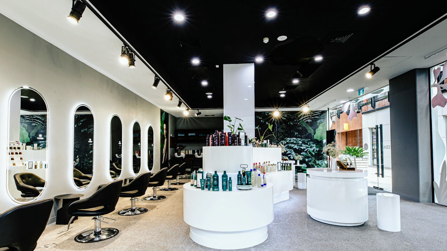 Chic interior of LUXM Docklands in Melbourne, Victoria, AU showcasing modern salon stations and products.