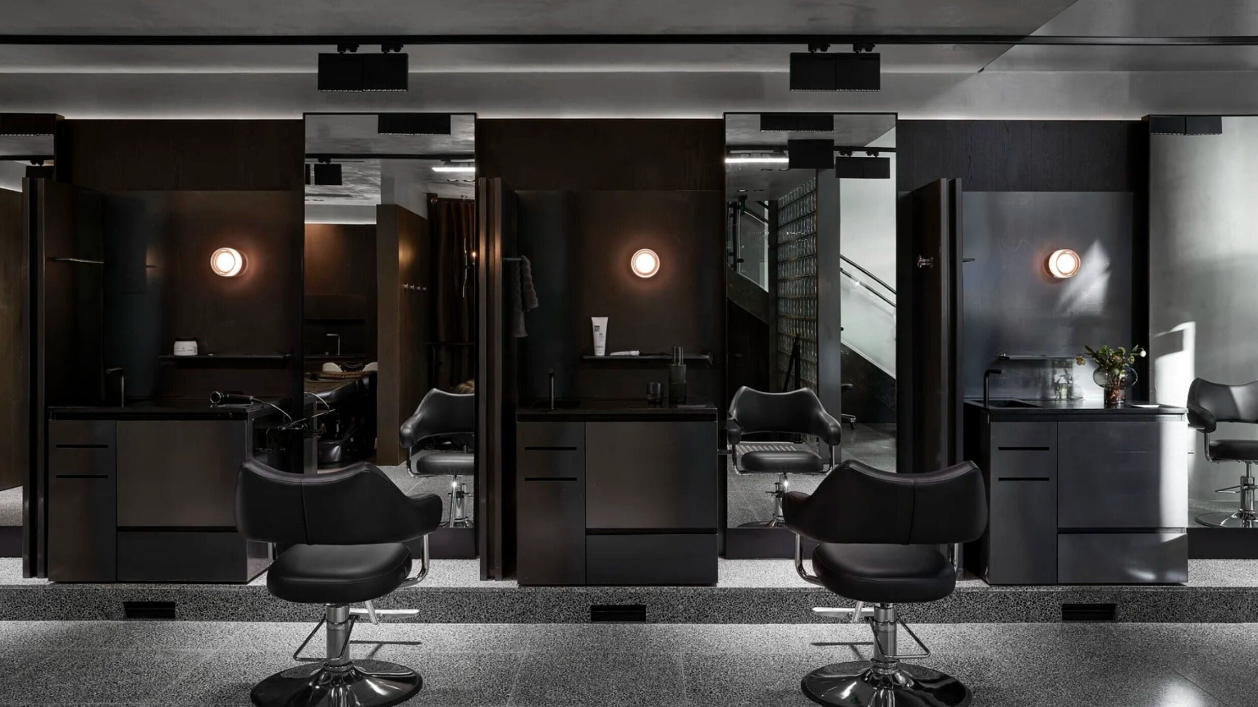Luxurious salon interior with sleek black chairs at LUXM Hooroo, Melbourne, Victoria, AU.