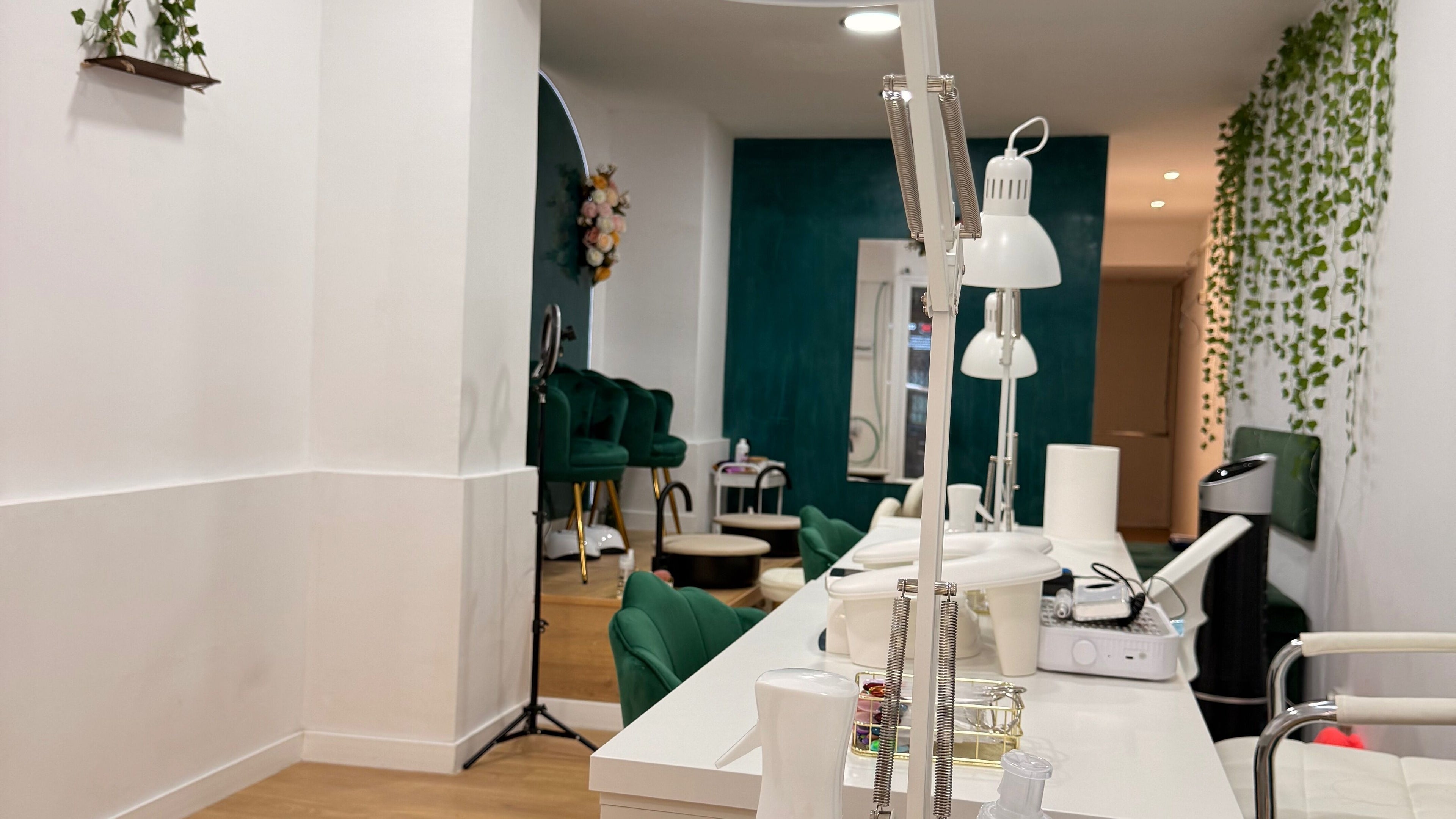 Interior elegante de Encanto de uñas en Barcelona, Catalunya, ES con sillas verdes y decoración moderna.