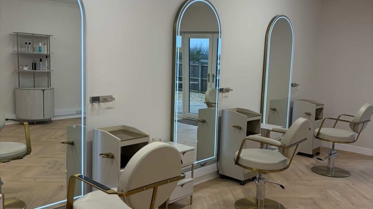 Modern salon interior at Caitlin Thompson in Leicester, England, GB with elegant chairs and mirrors.