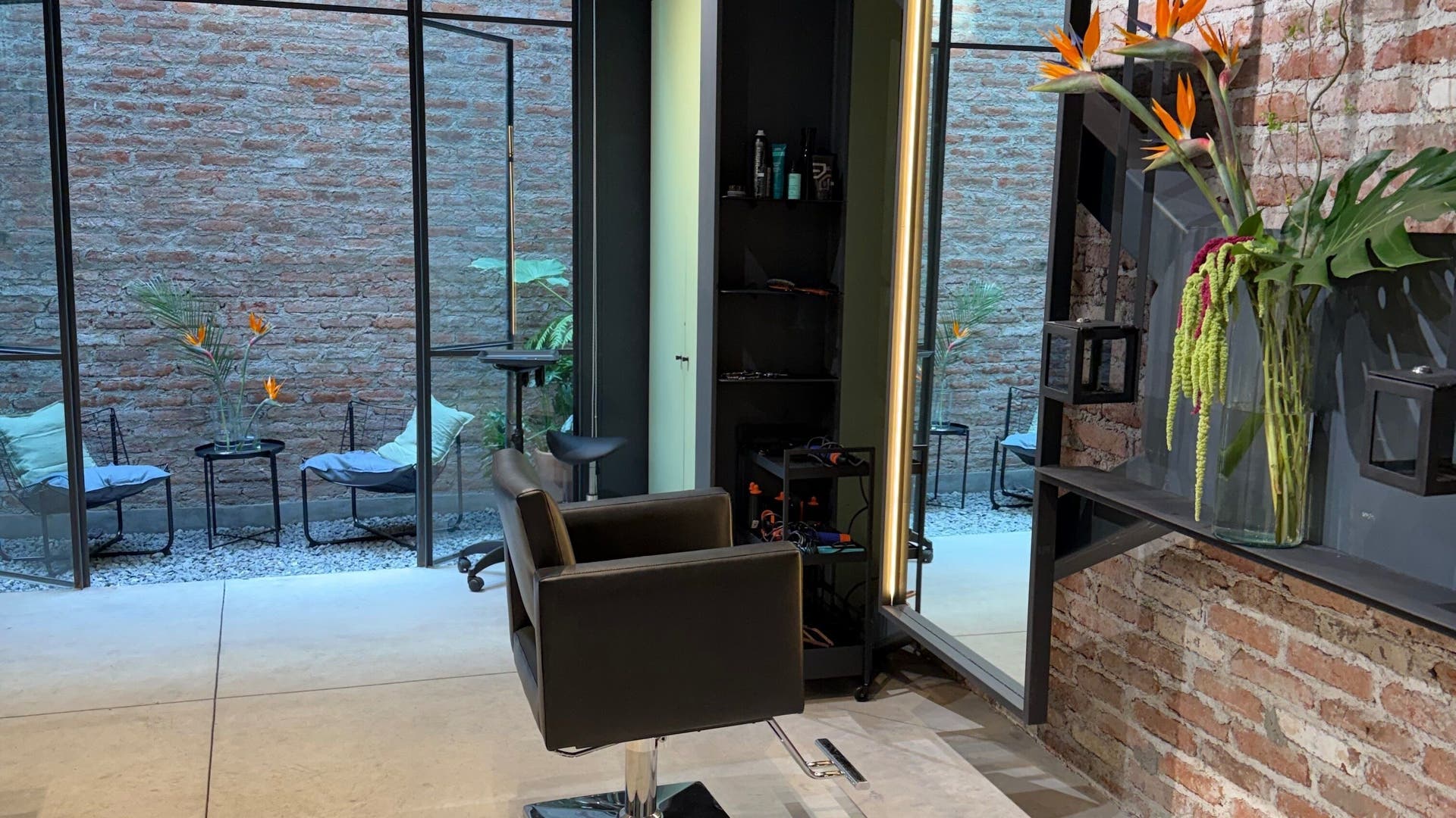 Interior moderno de Hair Studio Christoph Freisler en Ciudad De México, MX con silla estilista y decoración natural.
