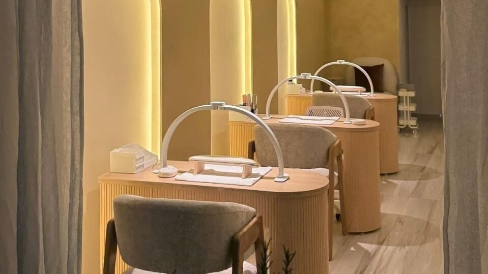 Estaciones de manicura elegantes en Blume Nail Studio, Ciudad De México, MX, con iluminación cálida.