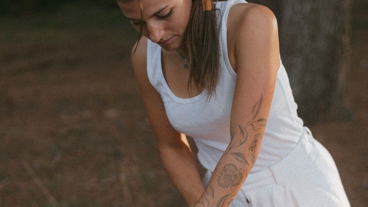 Sérane • Massage à Antibes: praticienne concentrée, tatouage floral sur bras. Antibes, Provence-alpes-côte D'azur, FR.