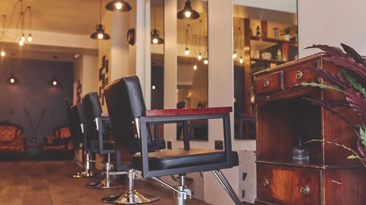 Elegant salon seating at EASTEND Well St, London, England, GB with vintage charm and modern lighting.