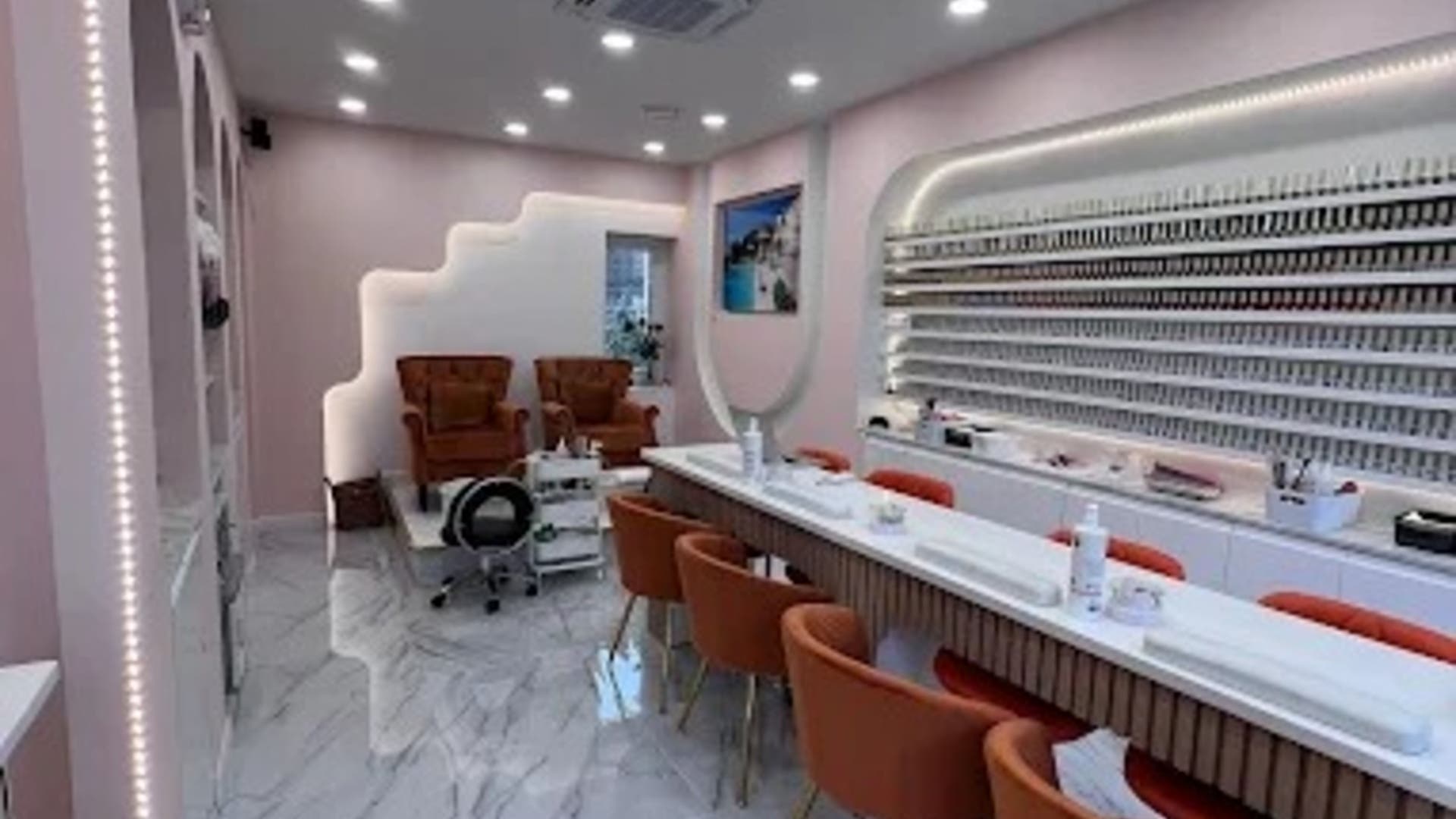 Elegant interior of Regal Nails in London with plush chairs and extensive polish collection.