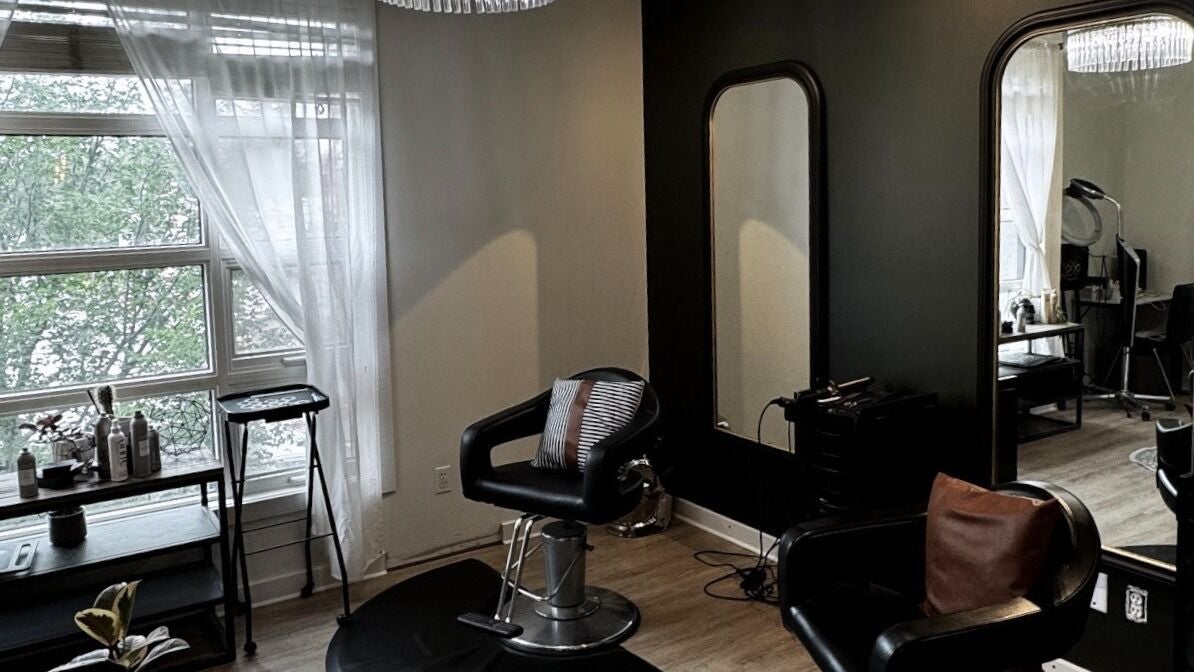 Elegant salon interior at Hair By Justin and Brittany, Calgary, AB, CA, featuring stylish chairs and natural lighting.