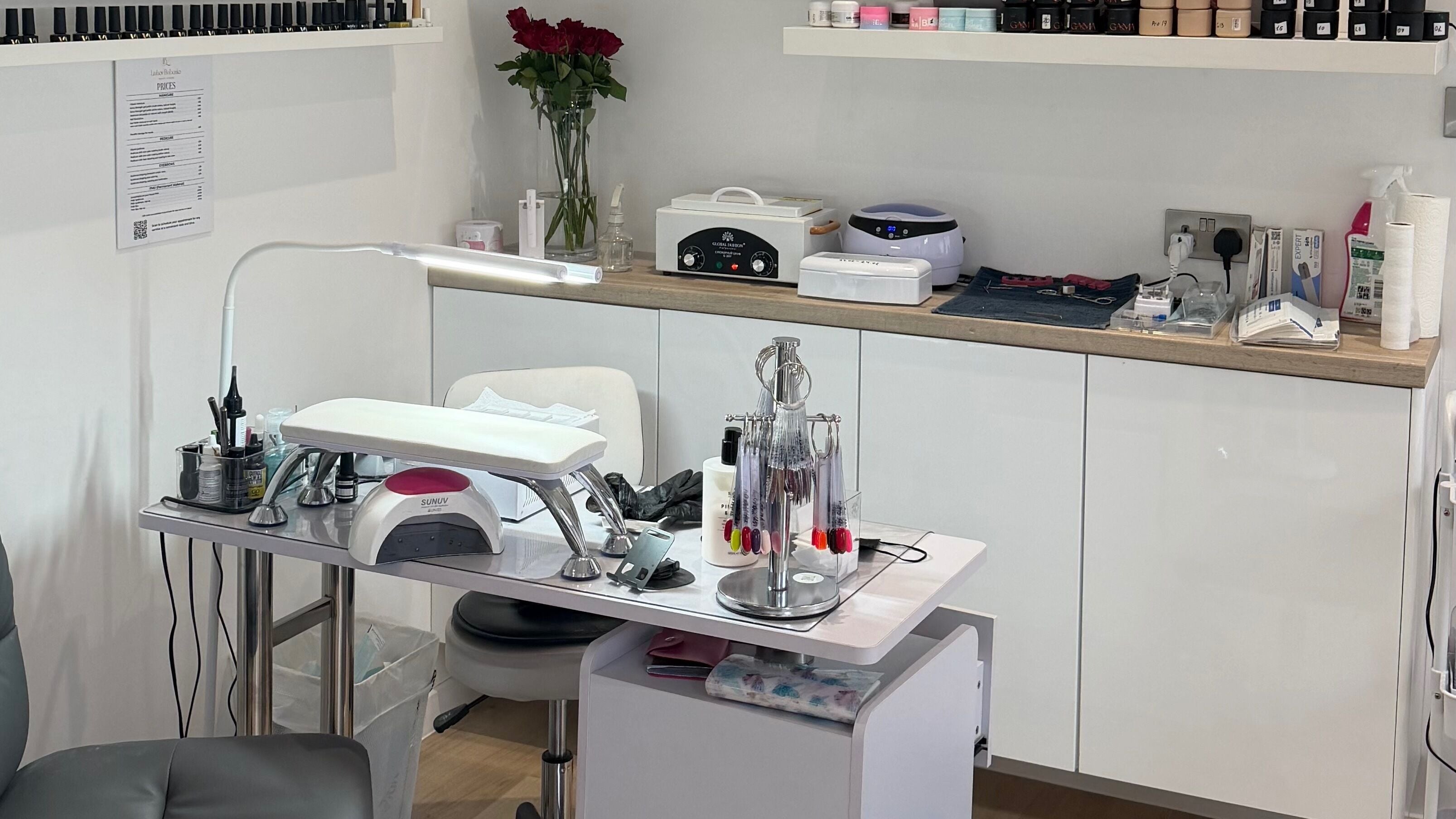 Manicure station at Lumi Nails in Glasgow, Scotland, GB showcasing a modern setup with tools and nail polishes.