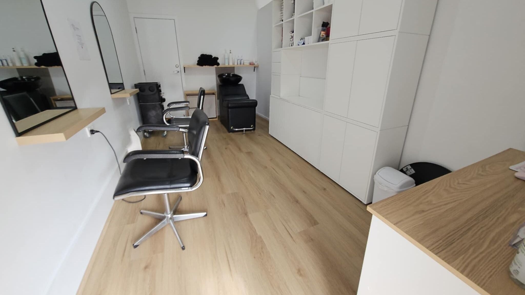 Modern salon interior at Natalie's Hair Design, Melbourne, Victoria, AU. Features sleek styling chairs and mirrors.