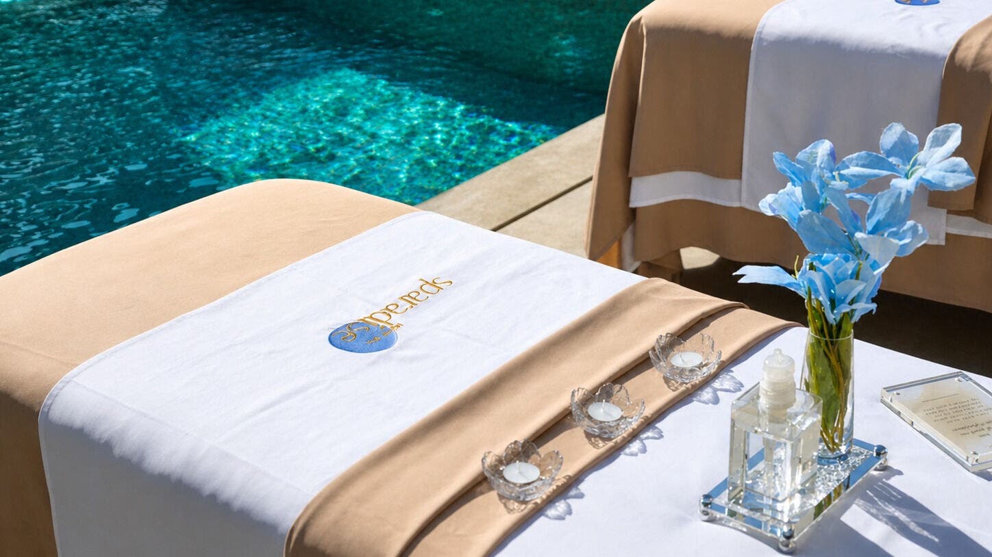 Outdoor spa beds by the pool at Sparadise Spa, Riyadh, Riyadh Province, SA, adorned with flowers and candles.