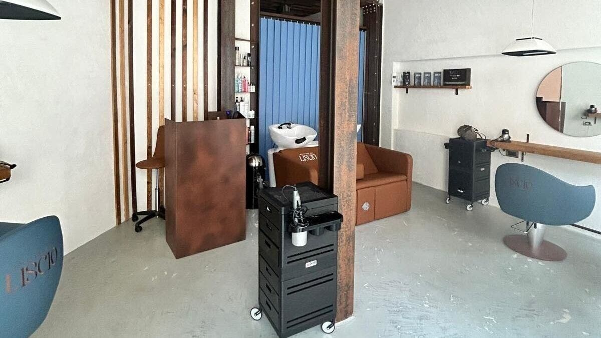 Interno elegante di OFFICINE DEL LISCIO a Milano, Lombardia, IT con arredi moderni e pareti in legno.