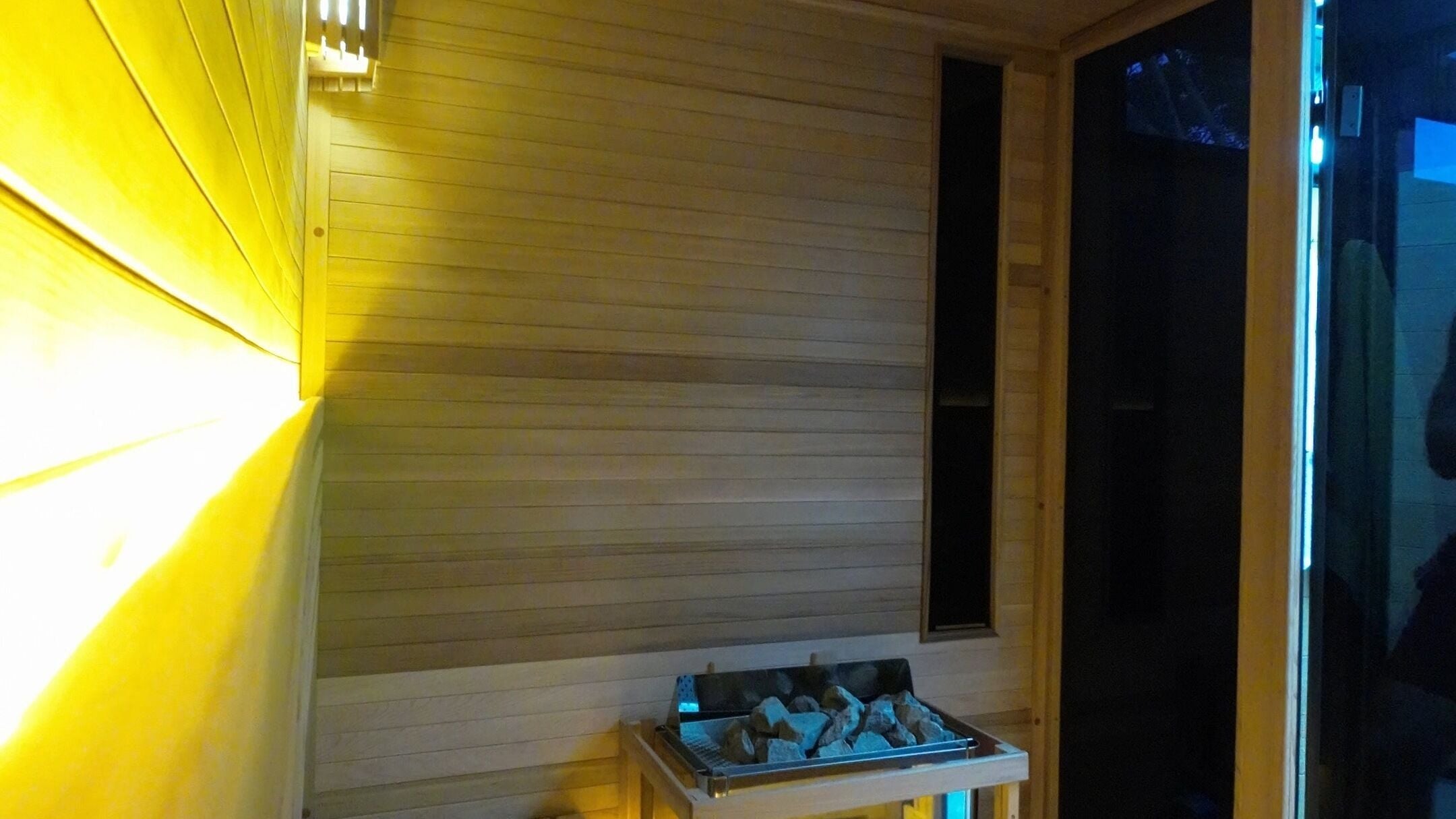 Relaxing sauna interior at Celsius Contrast, Auckland, Auckland, NZ, featuring cozy wooden walls and heated stones.