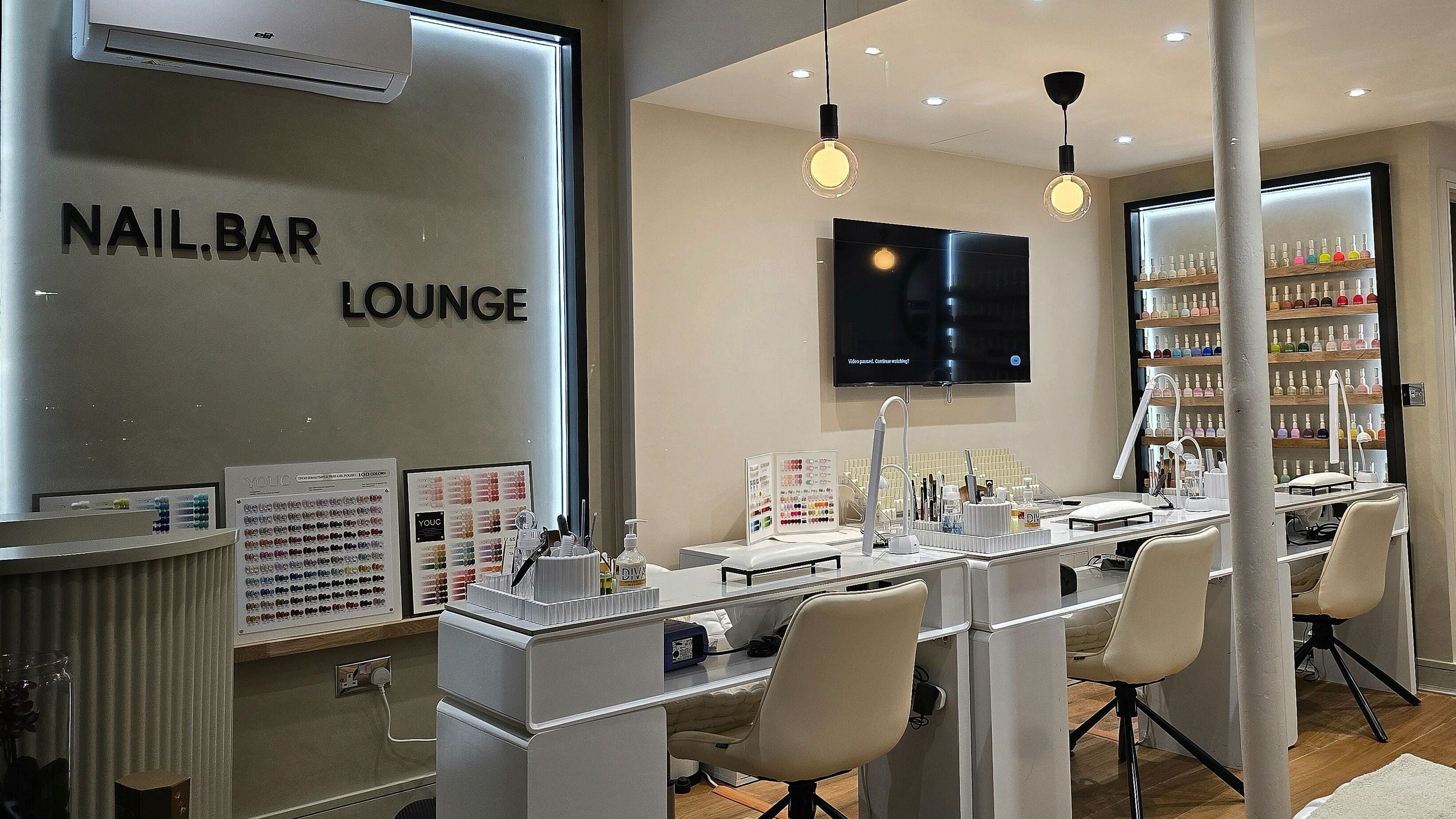 Interior of Nail.bar Lounge Balham in London, England, GB, featuring modern nail stations and polish displays.
