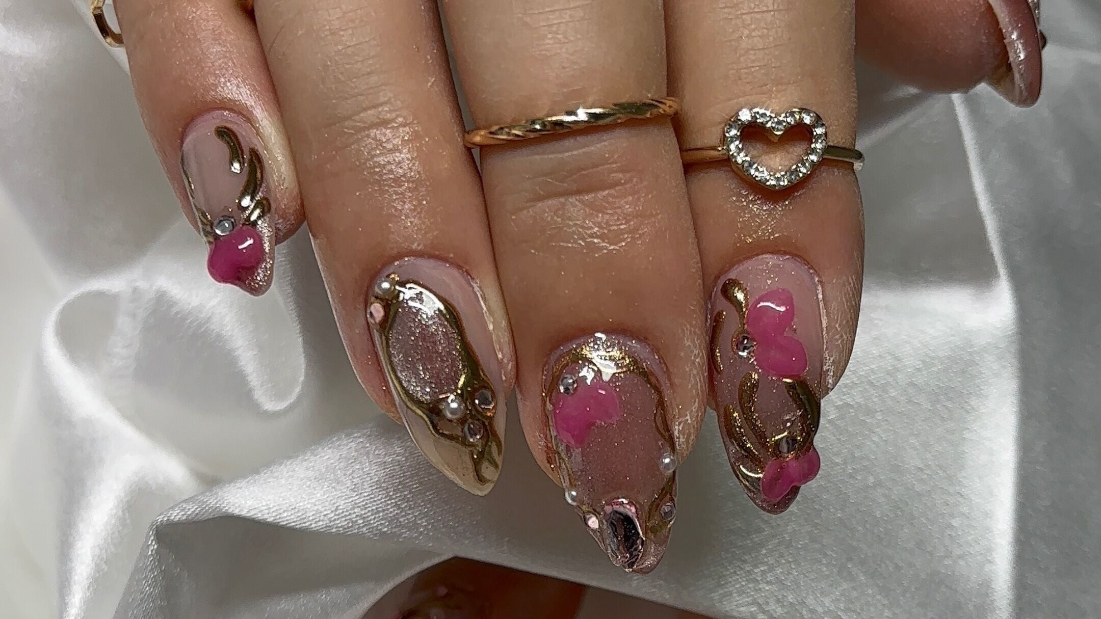Intricate nail art with gold and pink details at Glossynailsandspa, Calgary, Alberta, CA.