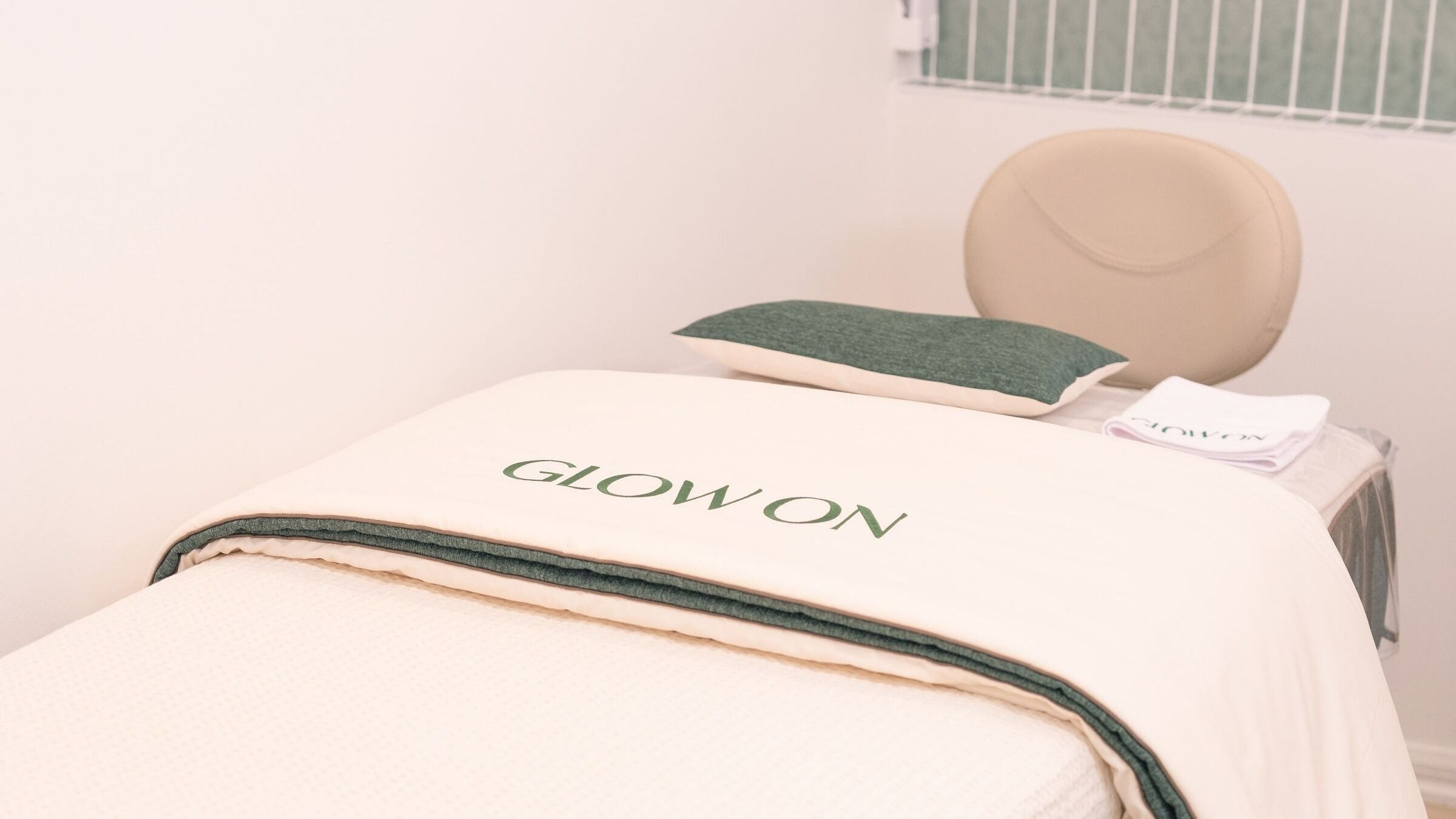 Relaxing treatment bed at GLOW ON Carnegie, Melbourne, Victoria, AU, featuring premium linens in a calming setting.
