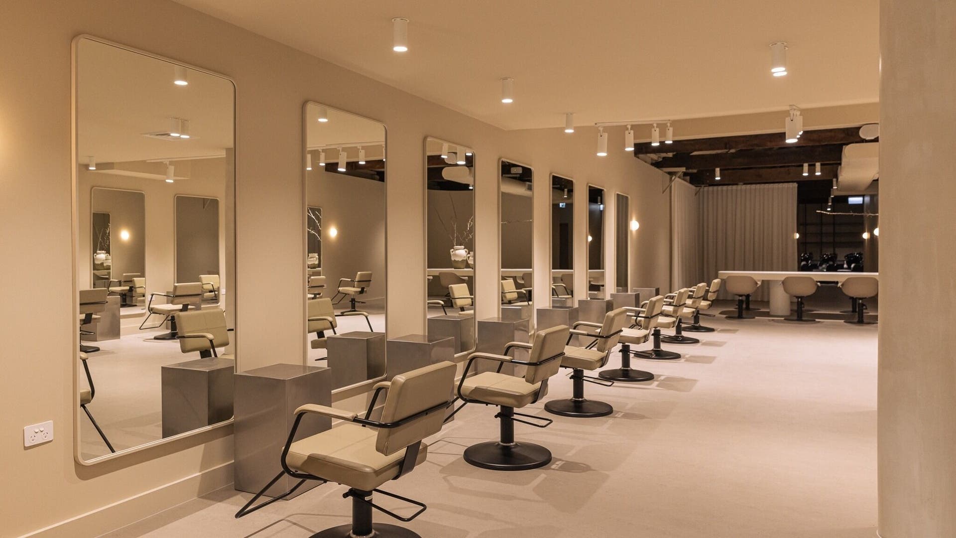Interior of Komo Hair salon in Preston, Victoria, AU, featuring modern styling chairs and large mirrors.