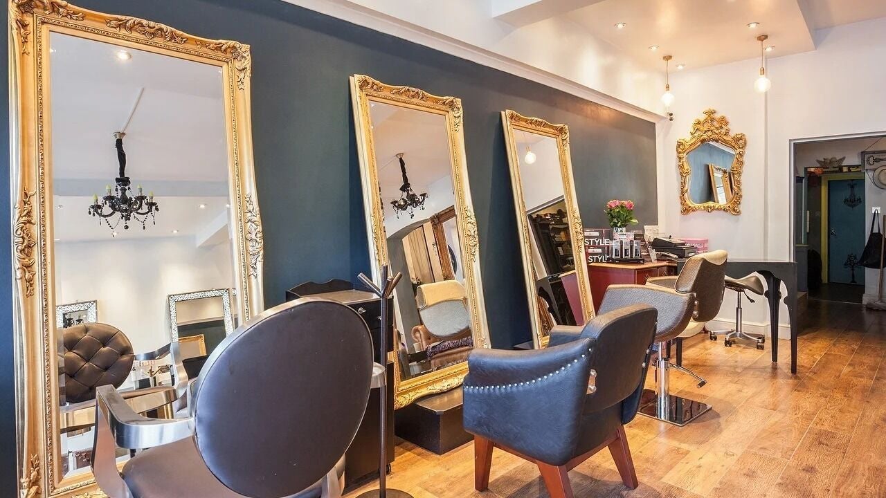 Luxurious interior of German Sercovick Hair Salon in London, England, GB, featuring elegant mirrors and plush seating.
