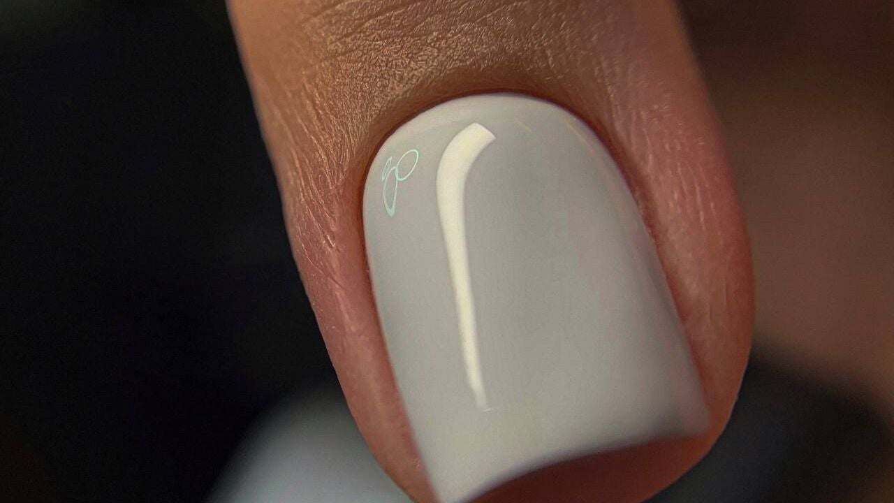 Glossy white pearl manicure at nailartnyc, New York, New York, US, showcasing professional nail care.