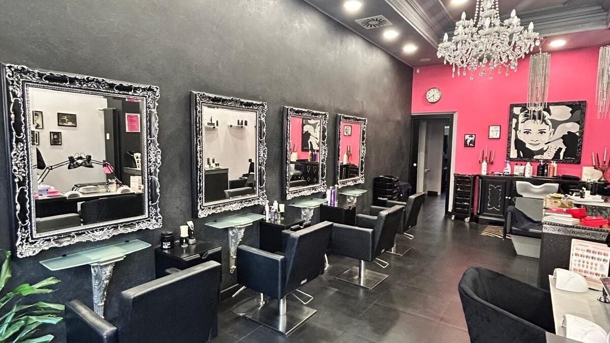 Interno elegante di Baldini parrucchieri a Milano, Lombardia, IT con specchi ornati e arredi raffinati.