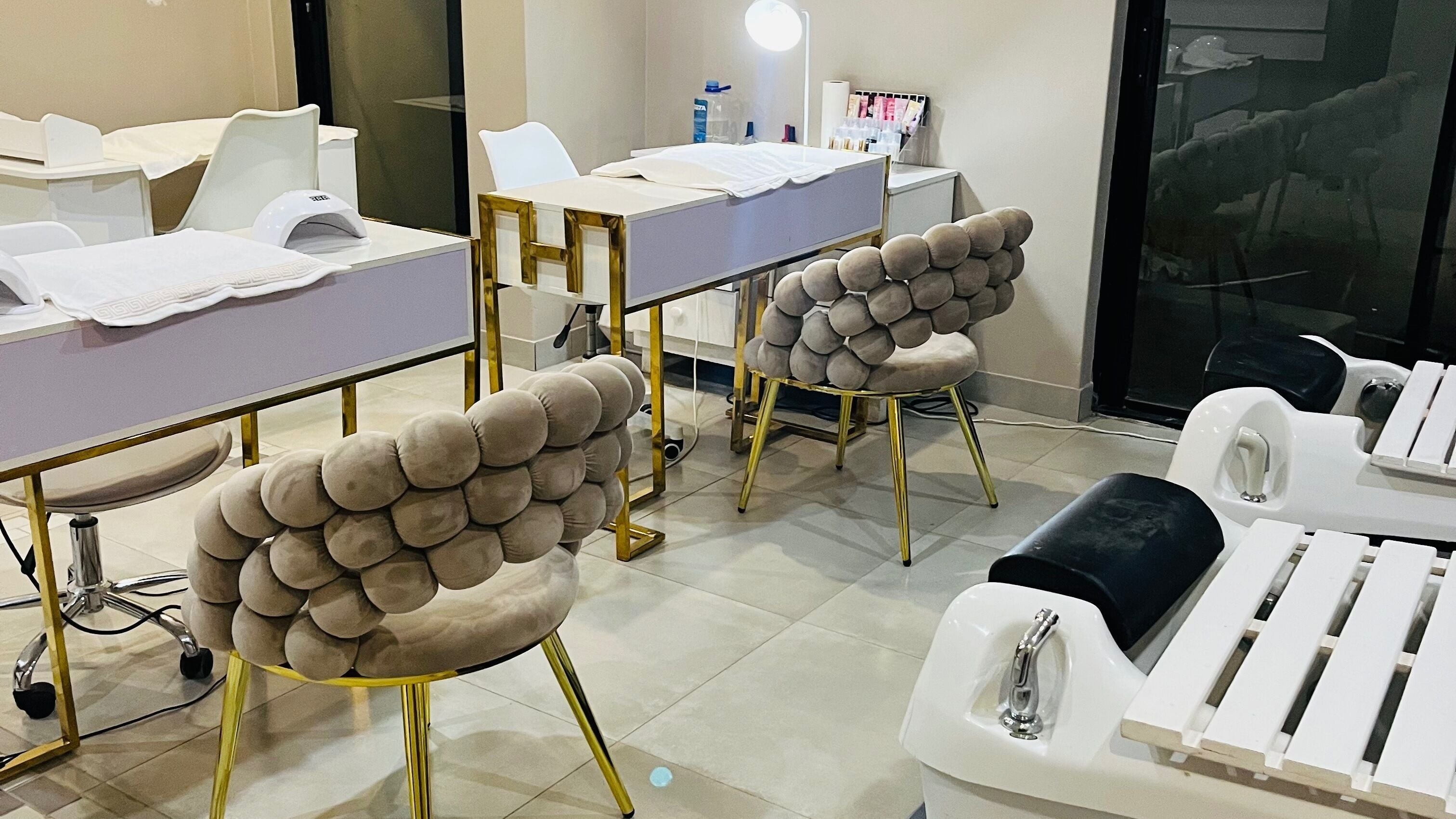 Elegant interior of PURE GEM NAILS, BEAUTY AND SPA in Pretoria, Gauteng, ZA with luxe seating and manicure stations.