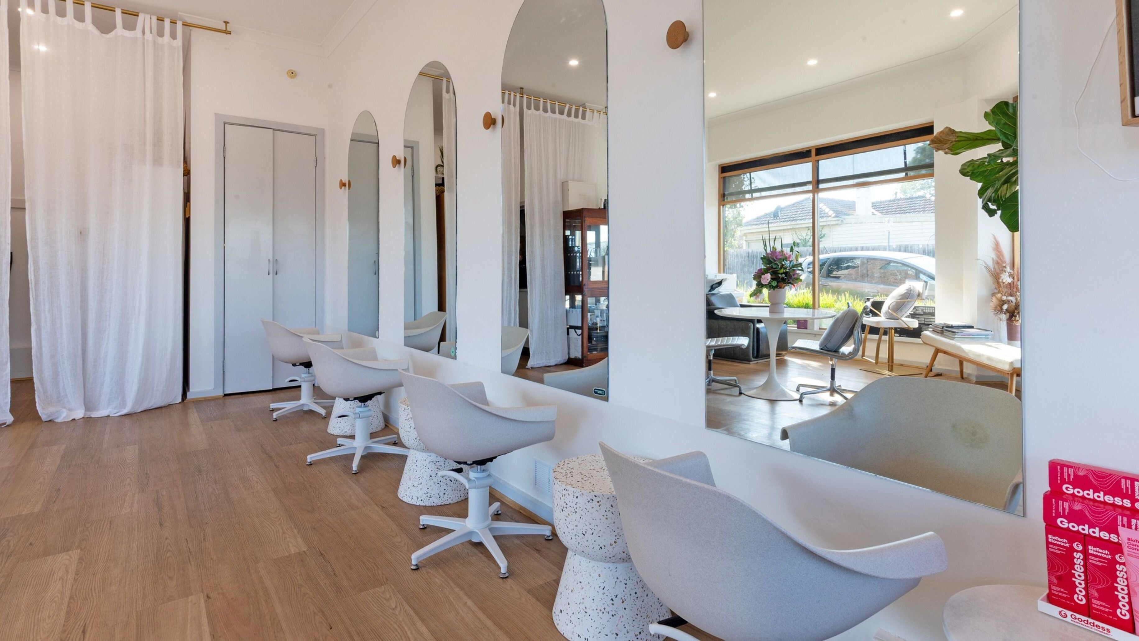 Modern salon interior at Lee Matthews, Cheltenham, Victoria, AU, featuring mirrors and stylish chairs.