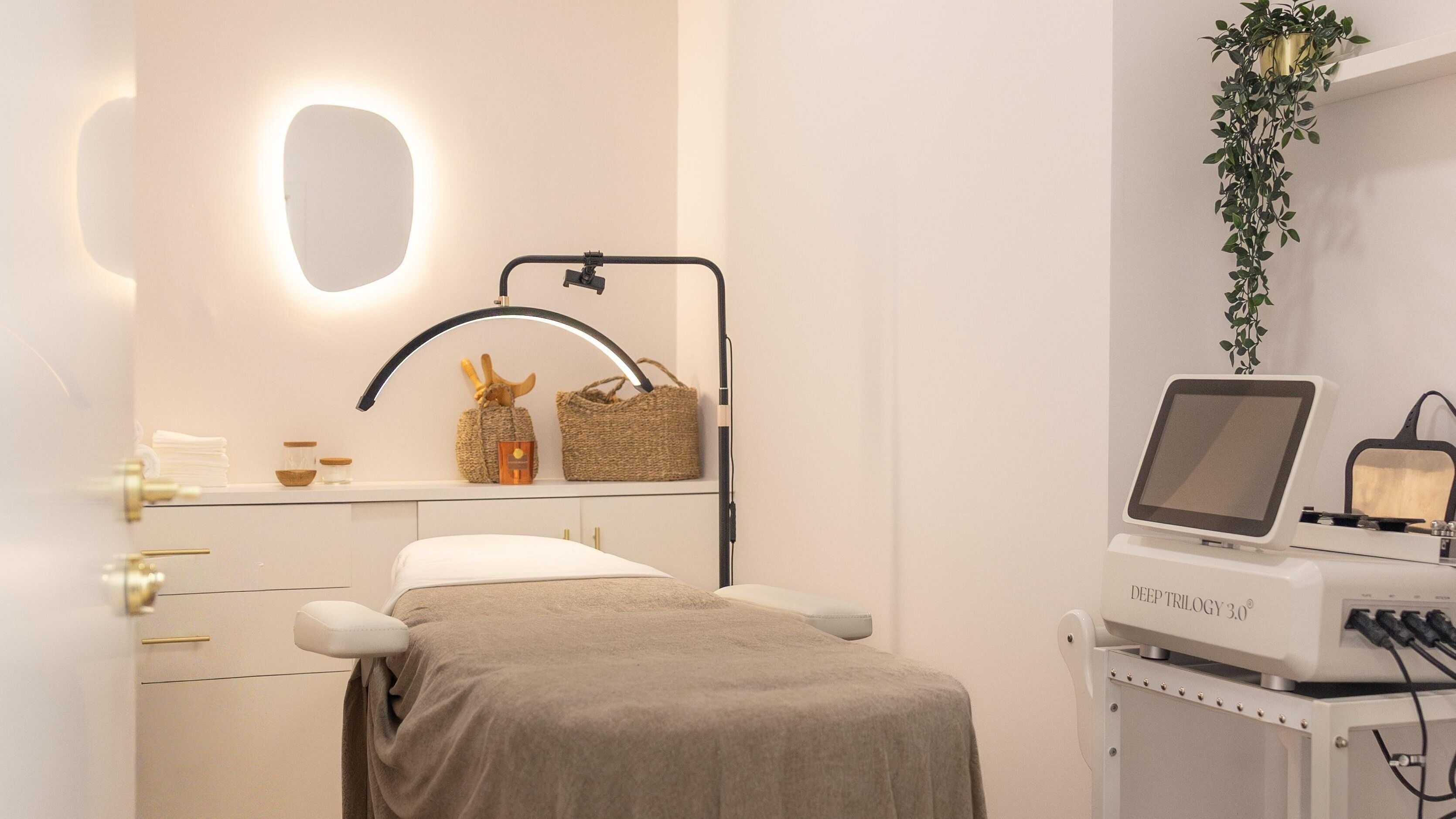 Sala de tratamiento en Del Cueto Skin Studio, Madrid, Comunidad De Madrid, ES, con cama y equipo especializado.