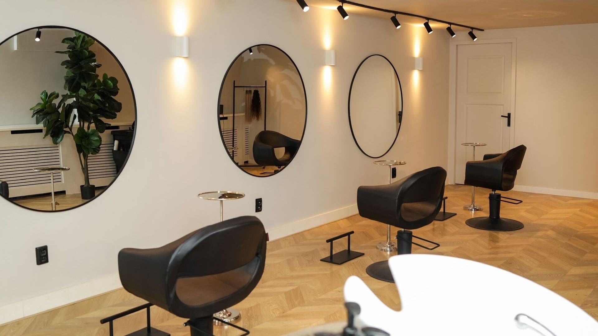 Moderne salon Glam by mooi met elegante spiegels en stoelen in Amsterdam, Noord-Holland, NL.