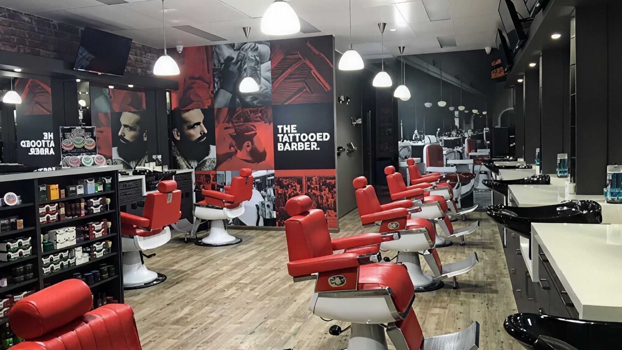 Interior of The Tattooed Barber, Melbourne, Victoria, AU with sleek red chairs and modern decor.