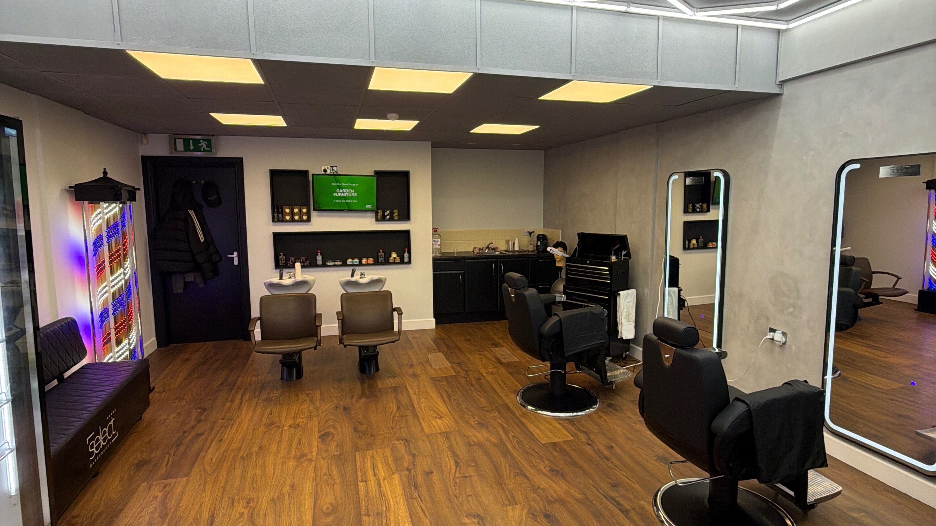 Modern interior of Select Barber Shop in County Galway, featuring sleek chairs and mirrors with vibrant lighting.