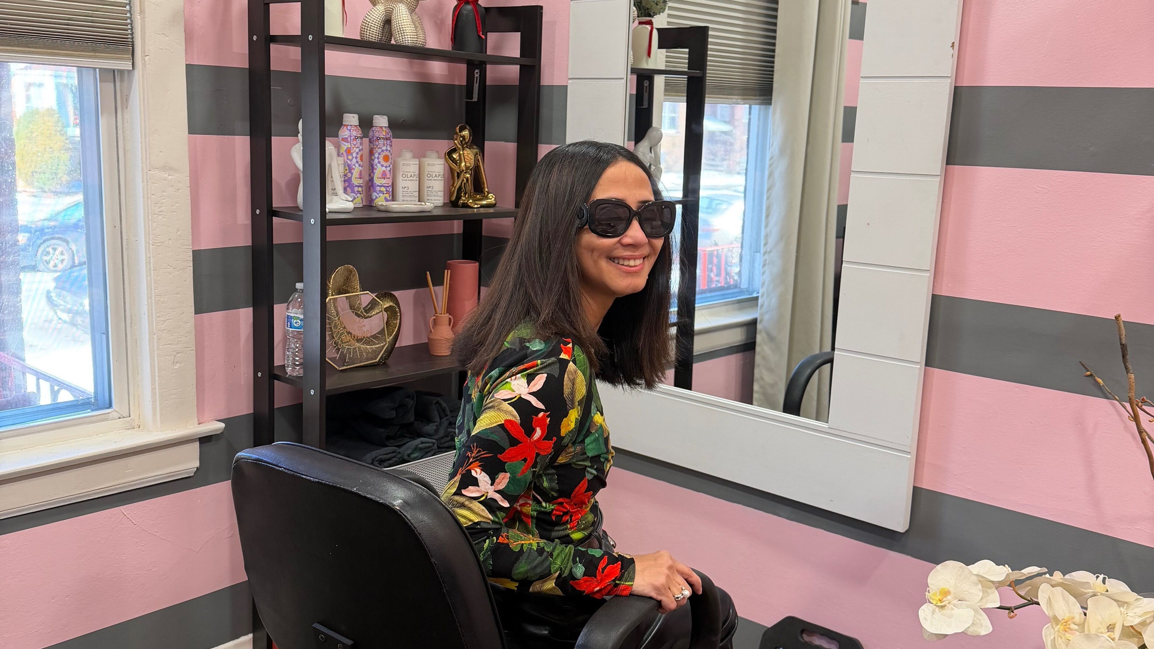 Interior acogedor de HAIR BY ERICKA DIAZ en Chicago, Illinois, US, con cliente feliz llevando gafas de sol.