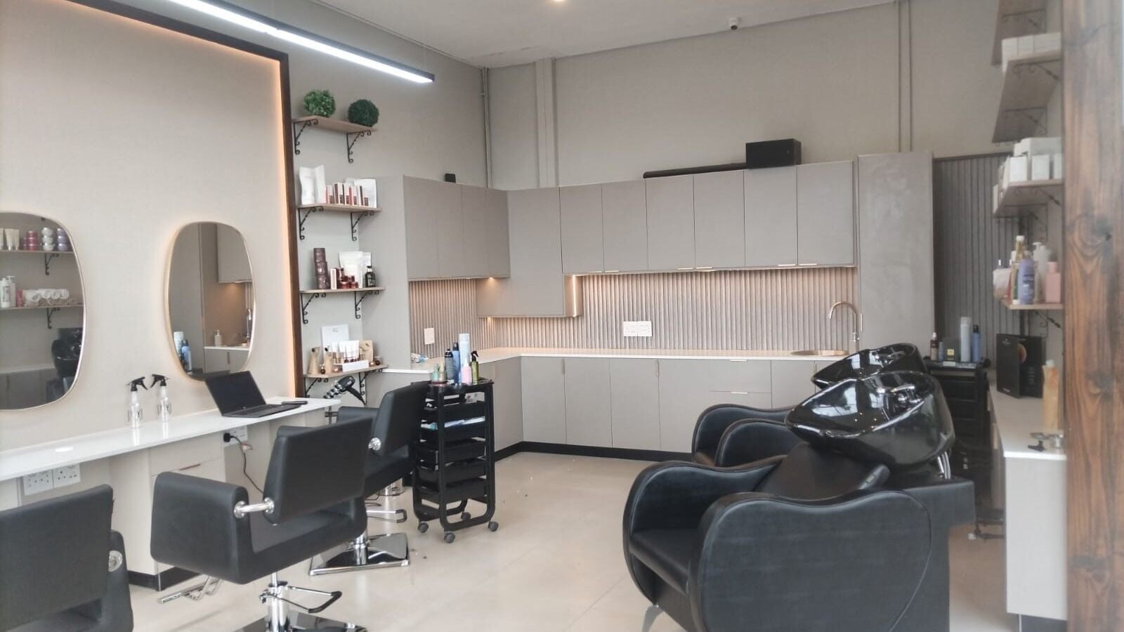 Modern salon interior at INCANTO HAIR AND BEAUTY, Centurion, Gauteng, ZA with styling stations and wash basins.