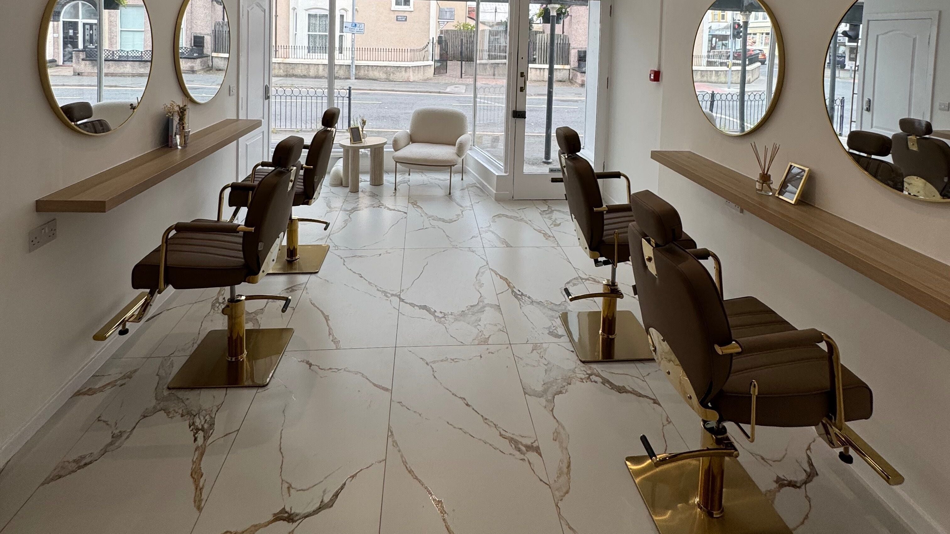 Elegant interior of Roè Hair Studio in Llandudno, Wales, GB, featuring stylish salon chairs and large mirrors.