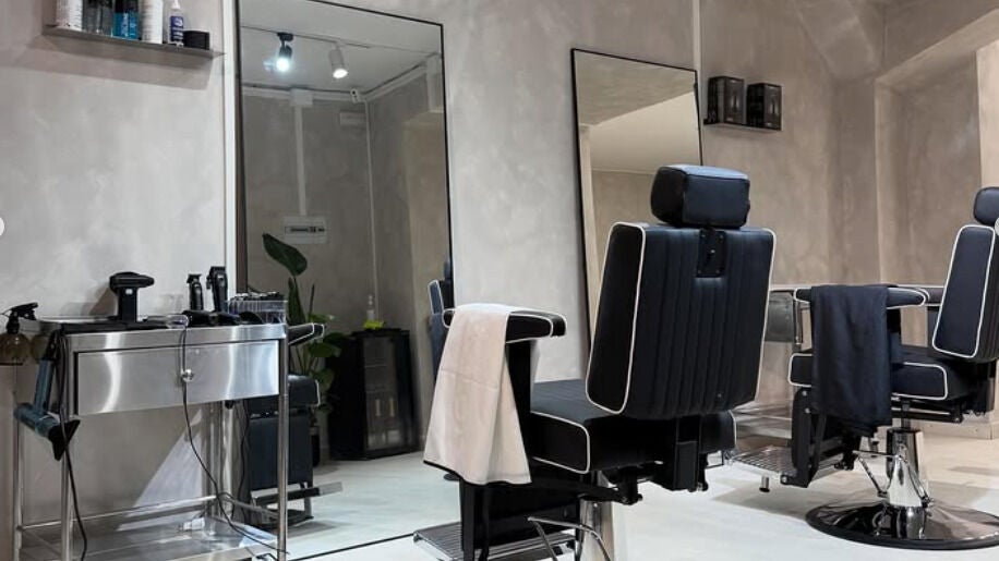 Interior elegante de Habit Studio en Barcelona, Catalunya, ES, con sillas modernas de peluquería.