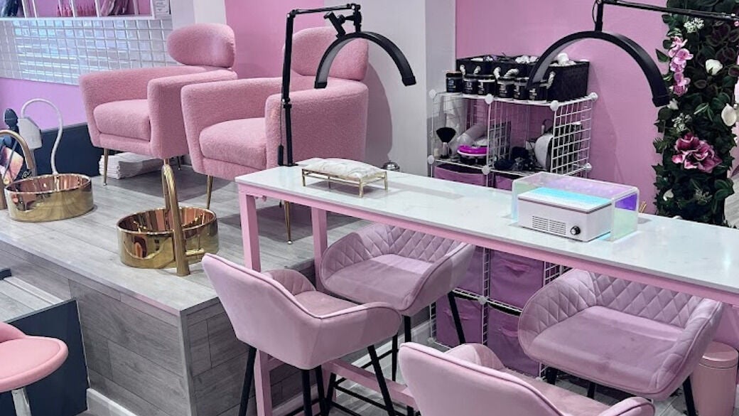 Interior of TK Beauty Bank in London, England, GB, featuring plush pink chairs and elegant manicure stations.