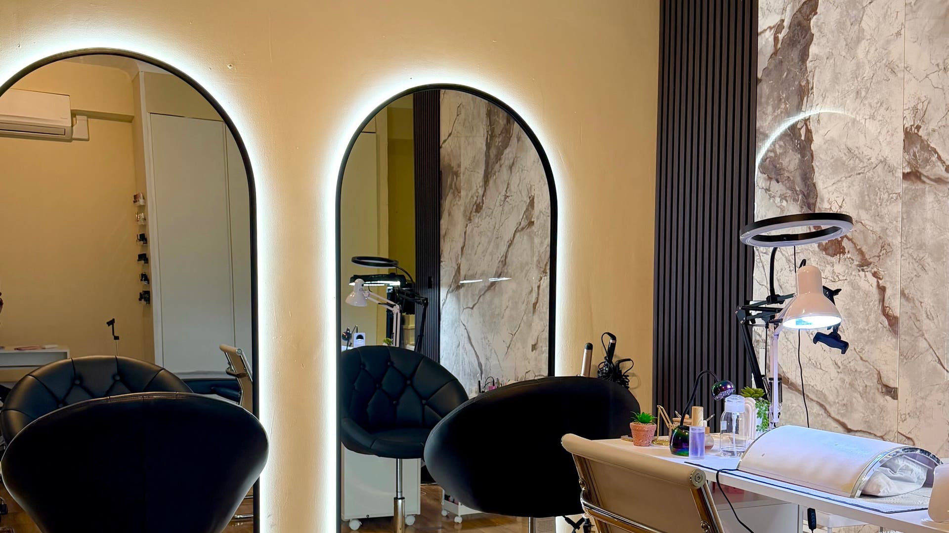 Elegant beauty station at Younique Beauty Makeup, Hair & Nails in London, England, GB featuring chic mirrors and cozy chairs.