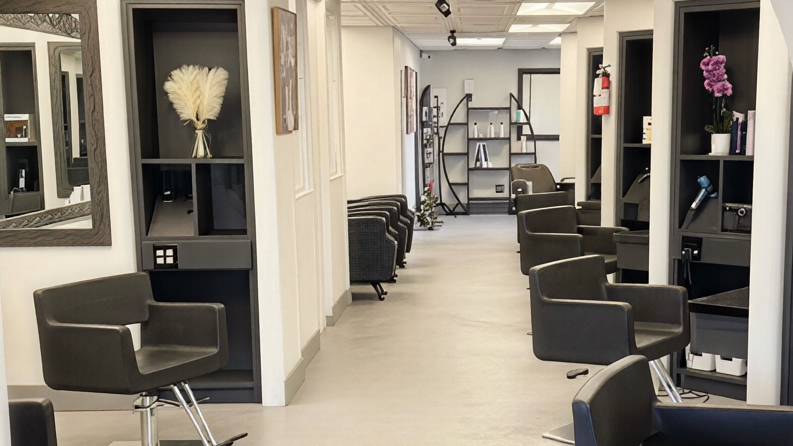 Modern interior of Diva Cuts Hair Salon in Huntington Beach, California, US. Comfortable styling chairs and sleek decor.