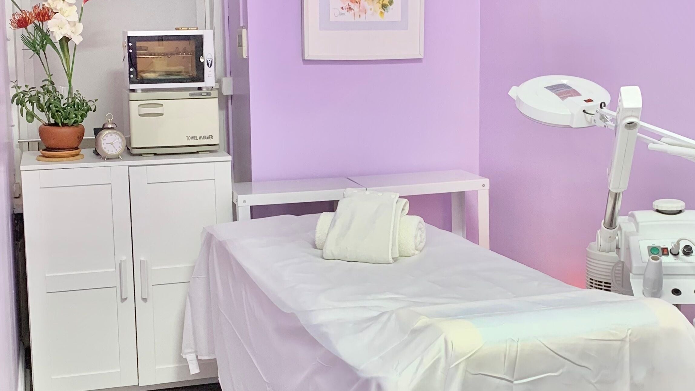 Tranquil treatment room at Le Bon Skin Lab in New York, New York, US with lilac walls and cozy setup.