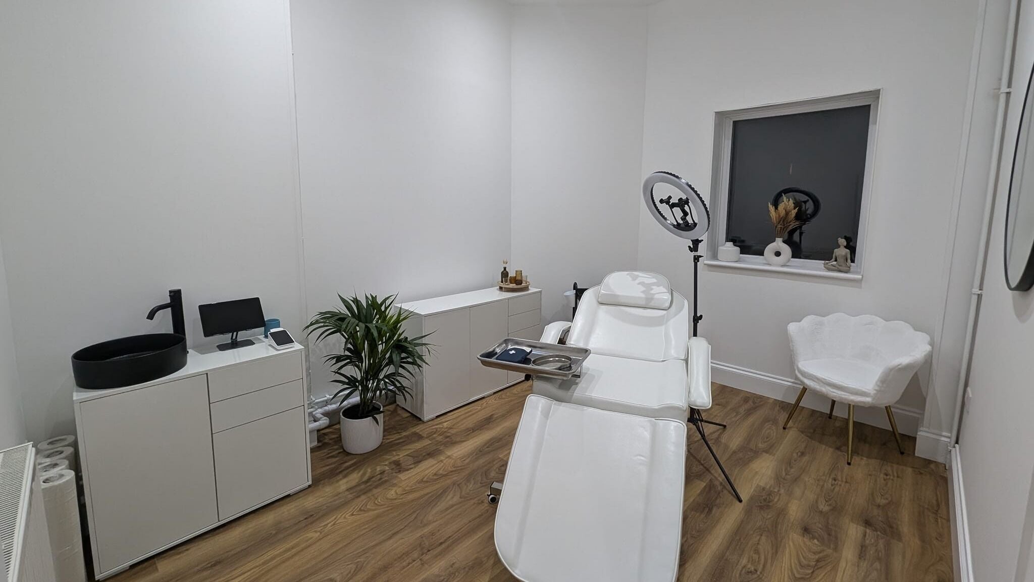 Modern beauty treatment room at Cara Marie, Polegate, UK with white furnishings and cozy ambiance.
