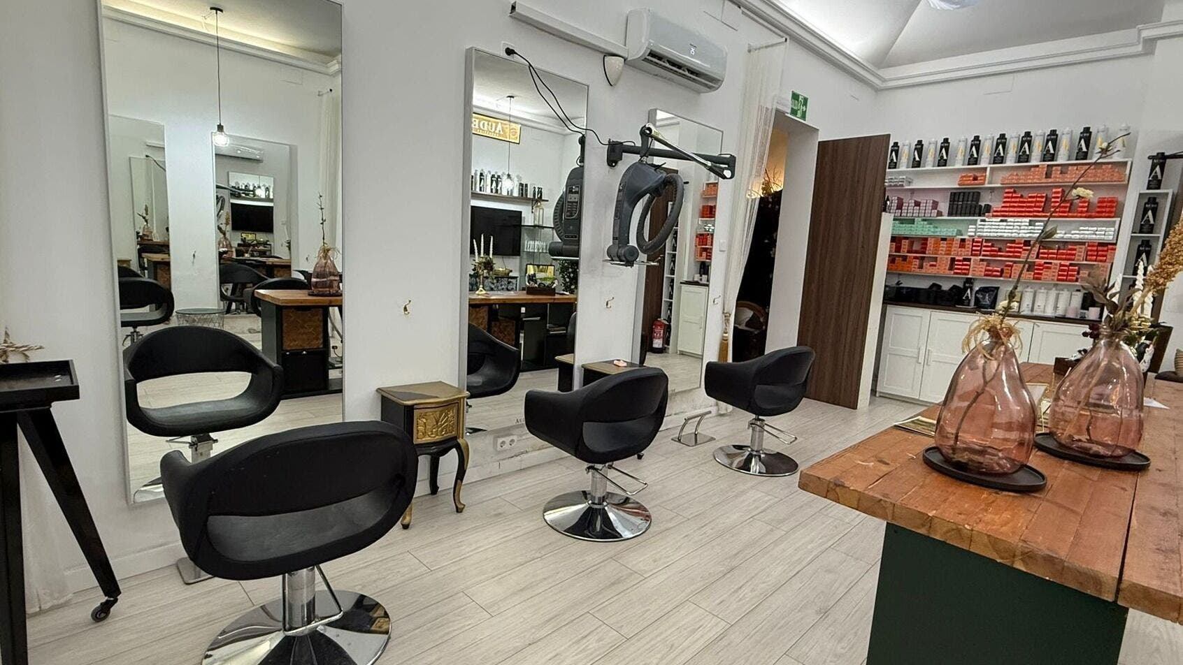 Interior moderno de Aude Perruqueria en Barcelona, Catalunya, ES con sillas y espejos elegantes.