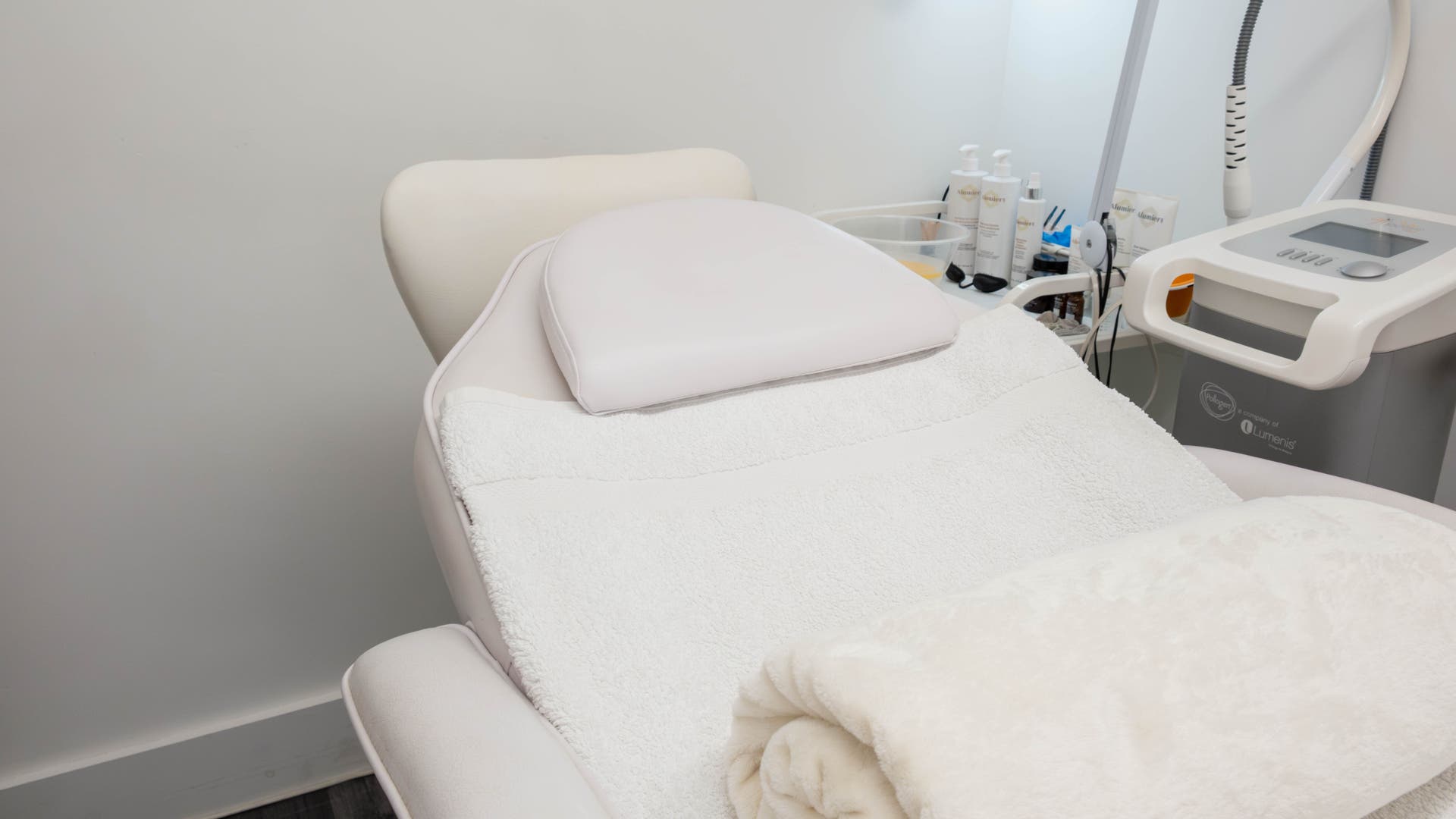 Luxurious treatment room at The Cure Clinic, London, England, GB, featuring a plush white bed and skincare equipment.