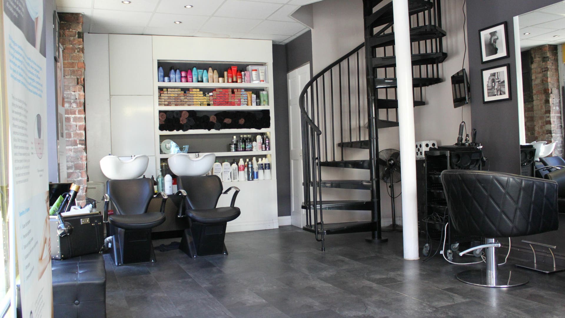 Interior of House of Hair Spitalfields, a modern salon in London, England, GB with sleek design and spiral stairs.