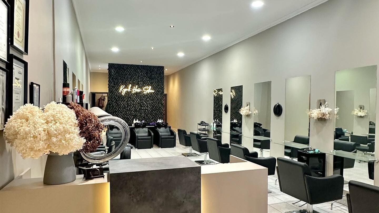 Elegant interior of Hair by Aroshi in Melbourne, Victoria, AU with sleek chairs and modern decor.
