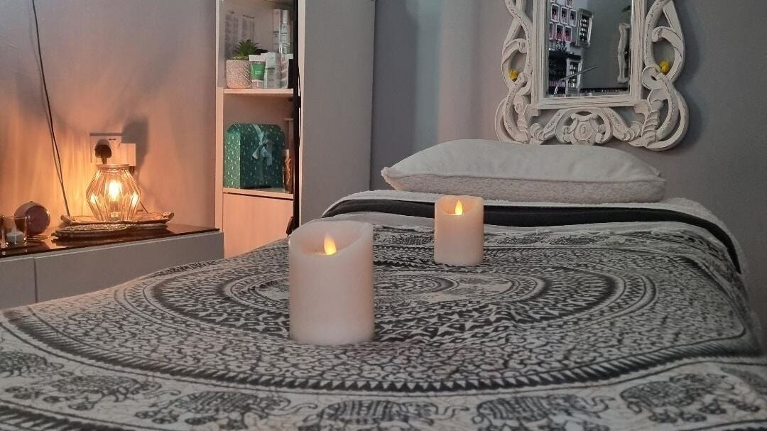 Tranquil massage room at The Beauty Retreat, Hailsham, England, GB, with soft lighting and candles.