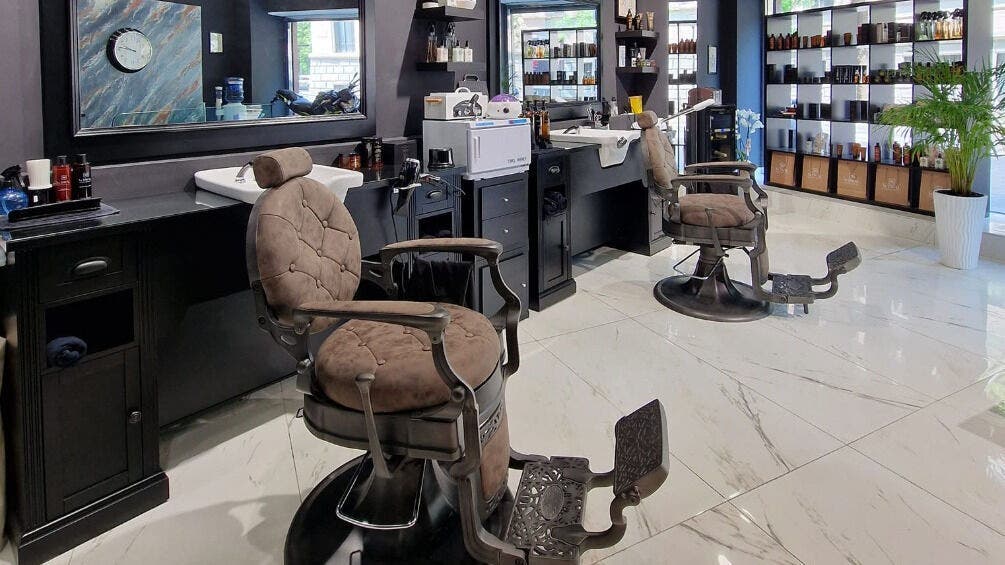 Interno elegante di Barber Lounge, Milano, con poltrone moderne e arredamento raffinato.