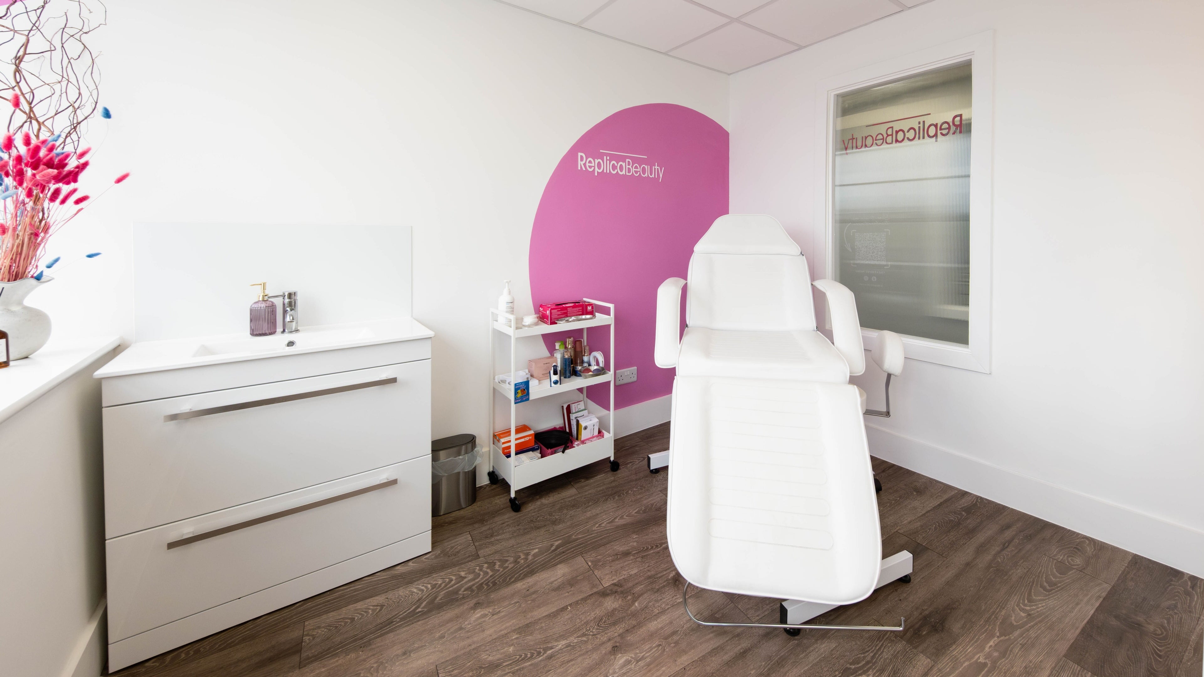 Bright and modern treatment room at Replica Beauty, London, England, GB, featuring a white reclining chair.