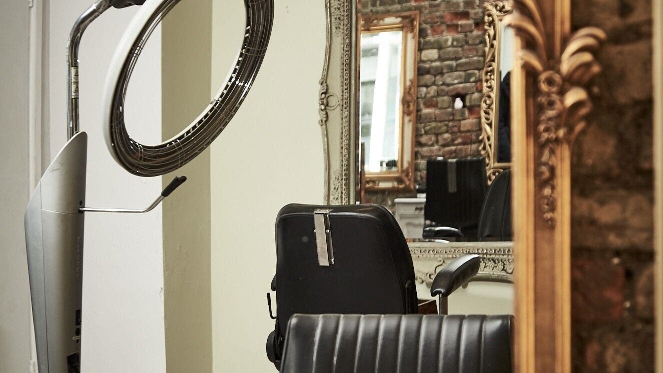 Modern hair salon chair and mirror at Kuki Hair, London, England, GB with elegant decor.