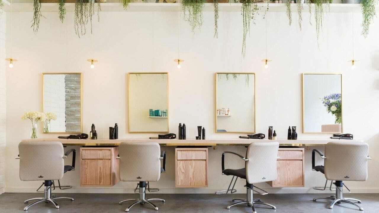 Elegant interior of Aer Salon, London, England, GB featuring styling chairs and mirrors for a luxe hair experience.