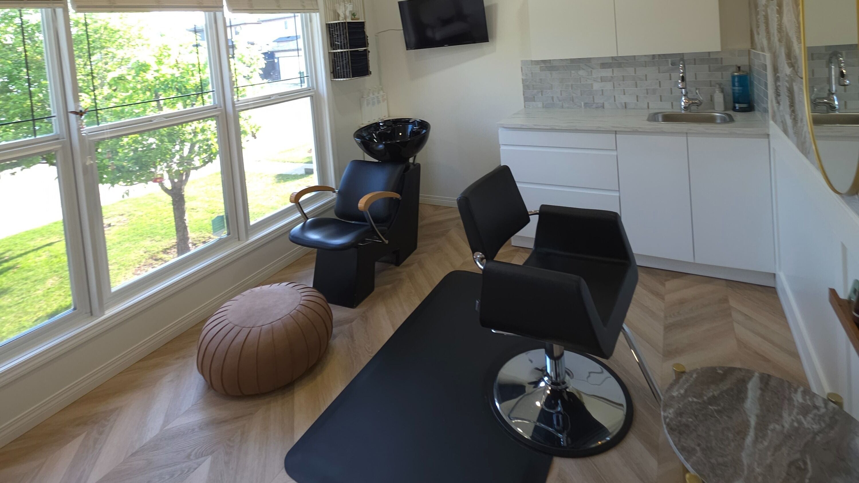Stylish salon at Calluna Hair, Calgary, Alberta, CA. Features large windows, modern seating, and sleek design.