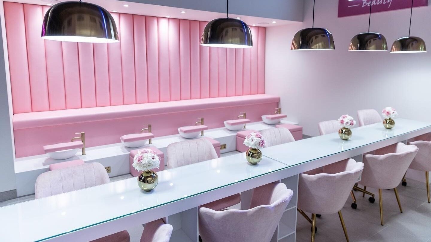 Elegant pink manicure area at Leon Beauty, London, GB, showcasing luxurious seating and stylish decor.